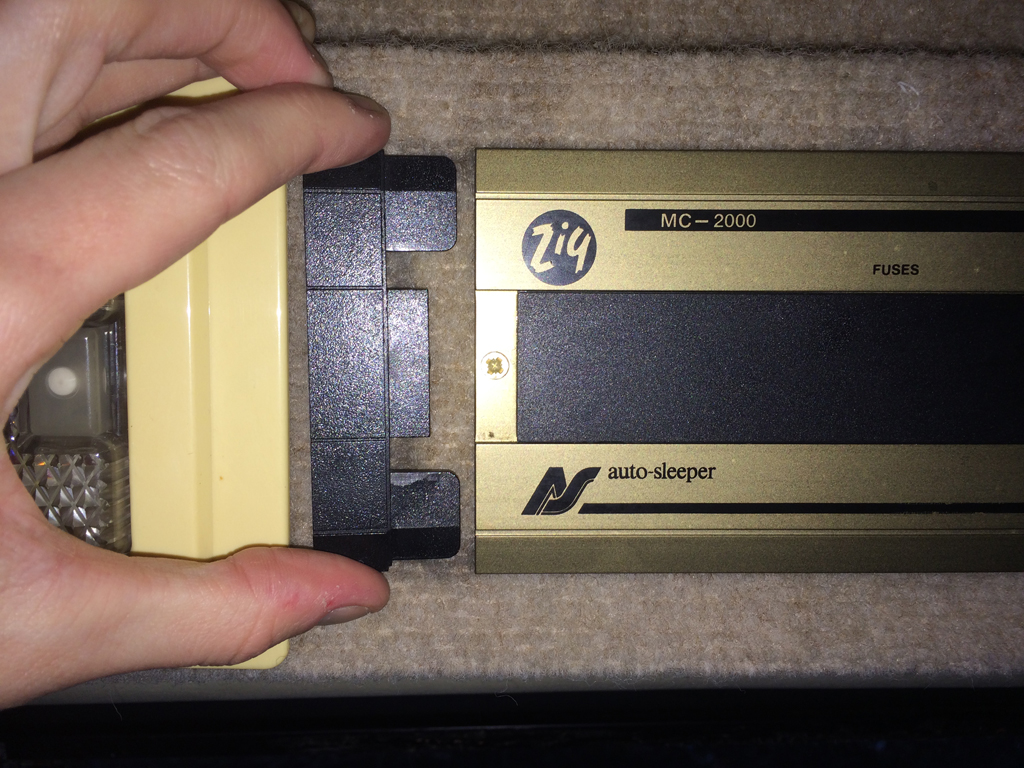 Slide the tab off to reveal a phillips screw